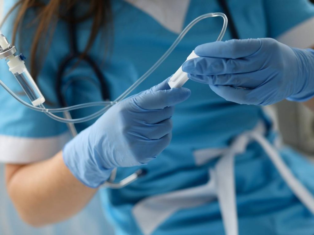 Primer plano de un estudiante de medicina preparando material para su TFG, simbolizando la dedicación en la investigación médica.